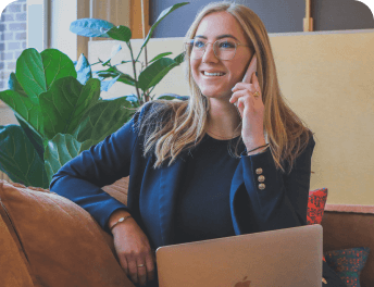 A woman is sitting in an armchair and talking on the phone