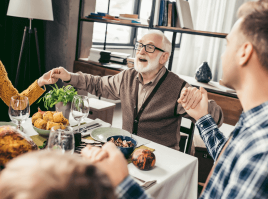 Family holding hands at the table