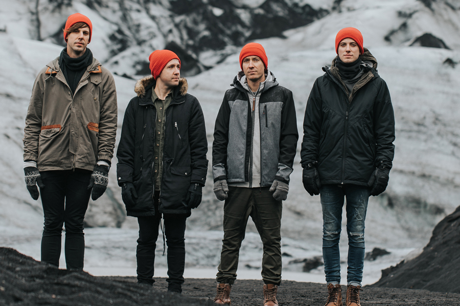 Four men standing against the background of mountains