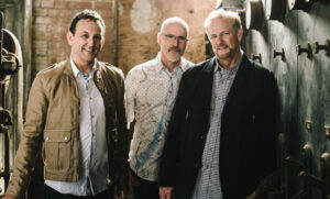 Three men standing in old factory
