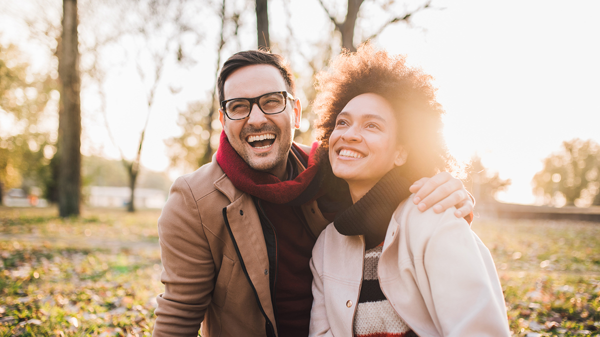 Happy couple sitting on the ground in a park