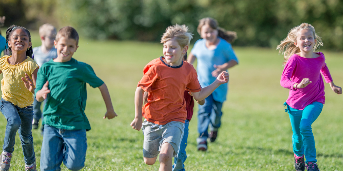 A group of children playing tag in a field outside
