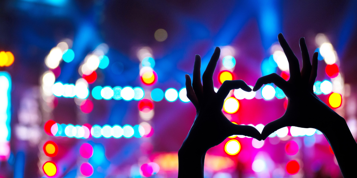 hands making a heart at a concert